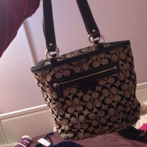 black and grey coach purse with purple inside.