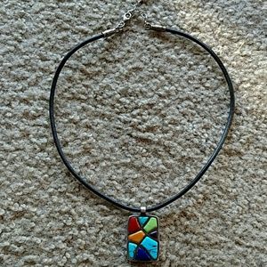 Leather rope necklace with multicolored pendant.