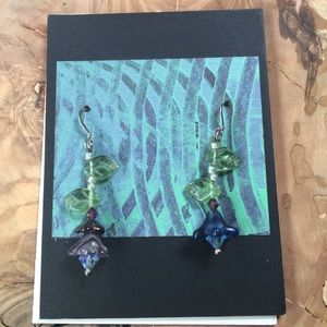 Glass bead one blue one purple. Green leaves