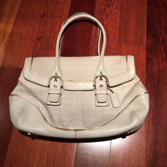 White Coach bag with gold buckles and gold trim.