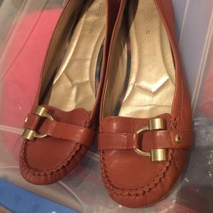 Brown loafer with gold buckle.