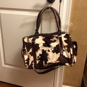 Cow print purse with removable strap.