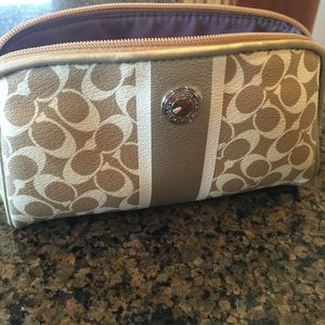 Coach- gold/tan on white background. Cosmetic bag