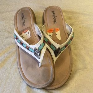 White flip flops with jewel designs.
