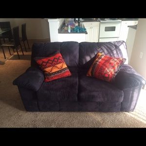 Black love seat with throw pillows.