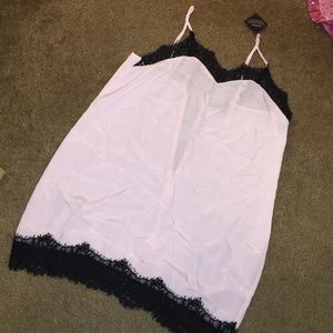 Nastygal pink slip dress with black trim.