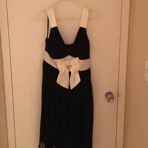 Black dress with white straps and bow.