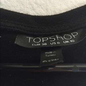 A black shirt with cut outs at the buttom