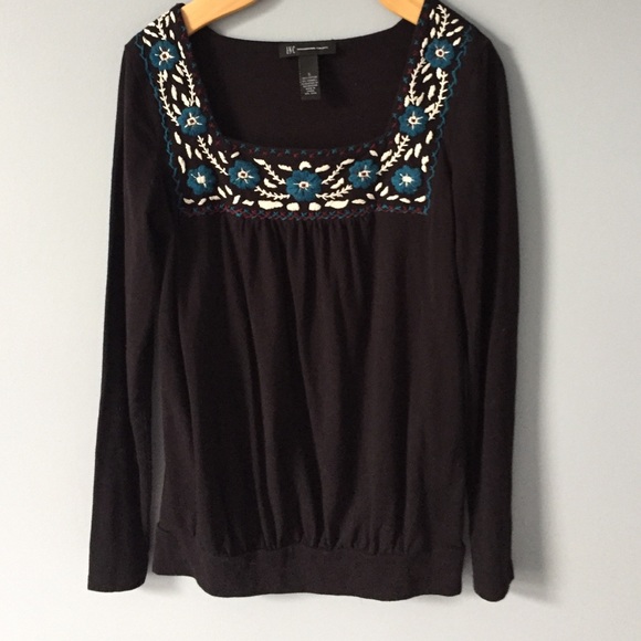 Adorable black shirt with floral details.