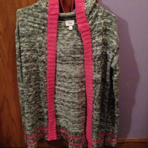 A sort of Cardigan black, white and pink item.