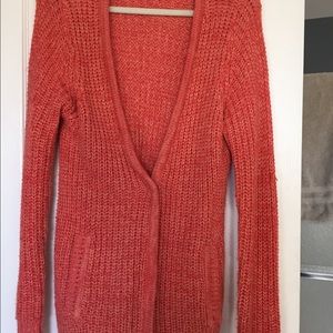 Orange colored longer cardigan with snap buttons