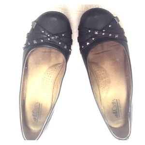 Black flats with silver stud and strap accent.