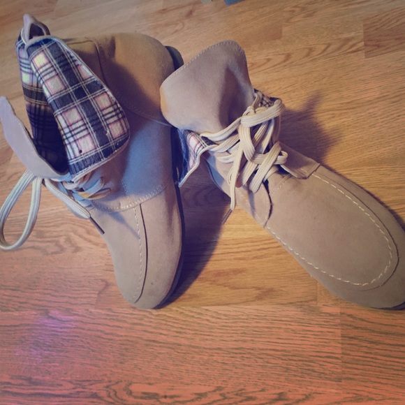 Tan moccasin boots with plaid folds.