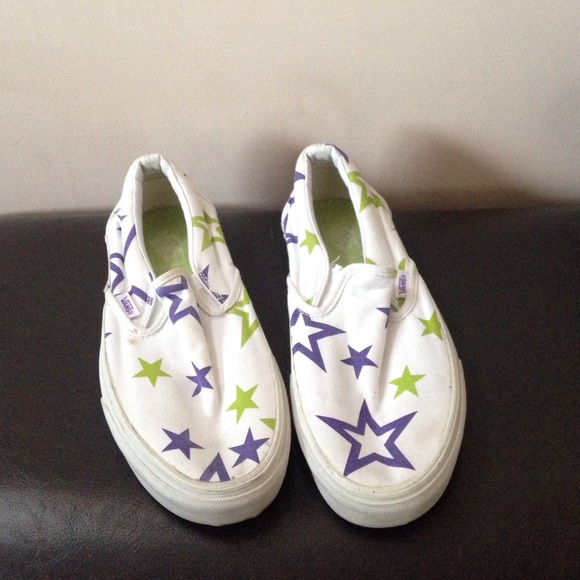 White slip-on Vans with purple and green stars.