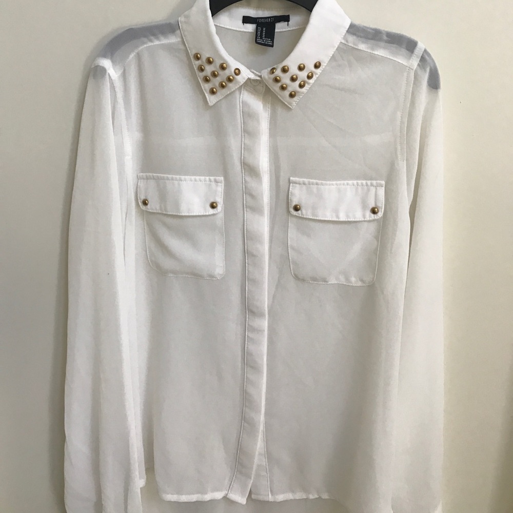White blouse with gold accents on collar.