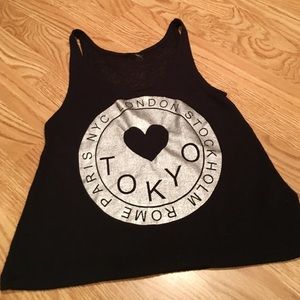 Black shirt, silver/metallic circle saying "Tokyo"