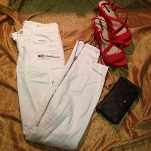 White pants with pockets and silver zippers.