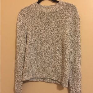 A high necked, navy and cream colored sweater.