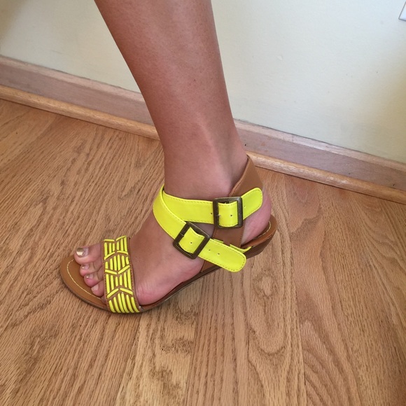 Brown sandal with bright yellow detailing.