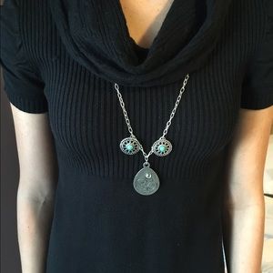 Long silver toned Om necklace.