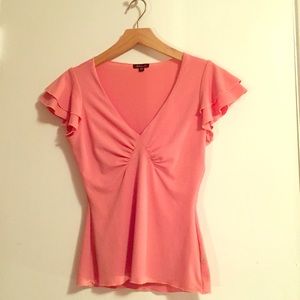 Peach blouse with ruffle shoulders.