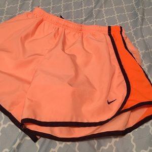 Orange nike shorts.