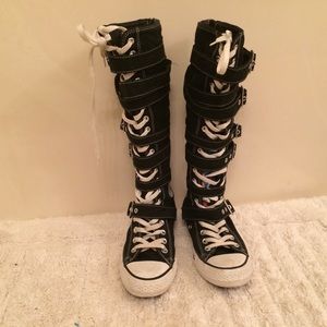 Tall Converse buckled knee high shoes.