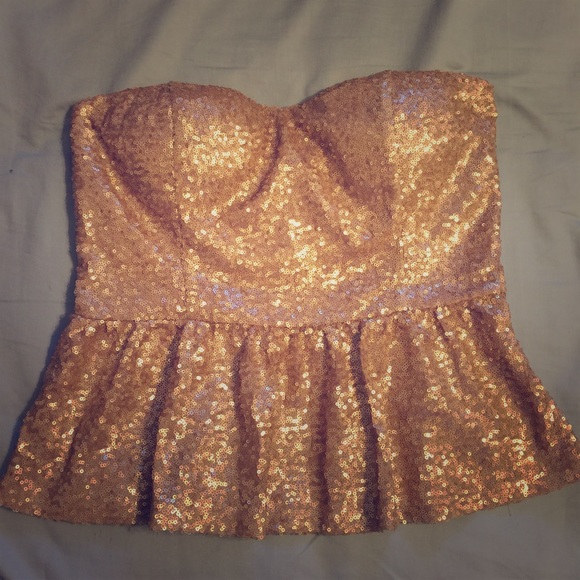 Gold sequined peplum strapless top.