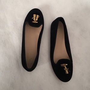 Versatile black loafers with gold tassels.