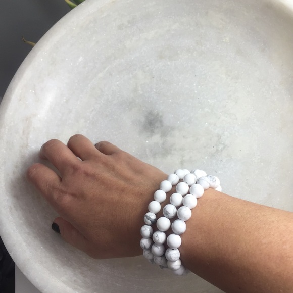 Set of three white Faux marble bead bracelets.
