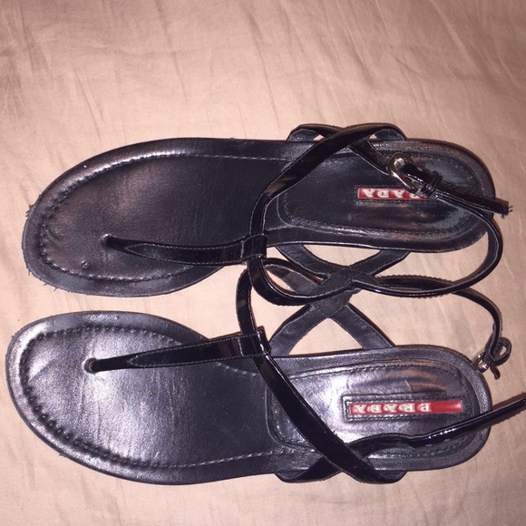Prada wedge sandals in black patent leather.