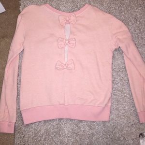 Pastel pink crew sweater with bows on the back.