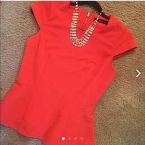 Orange peplum top with statement necklace