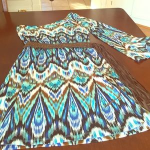 A colorful one shoulder dress with fringe belt