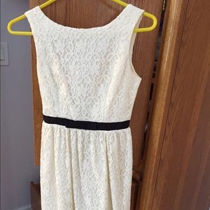 A cream dress with a black belt