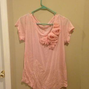 A light pink short sleeve shirt with detailing