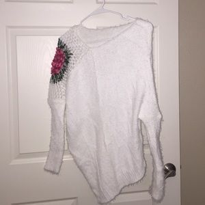 White sweater with knitted flower.
