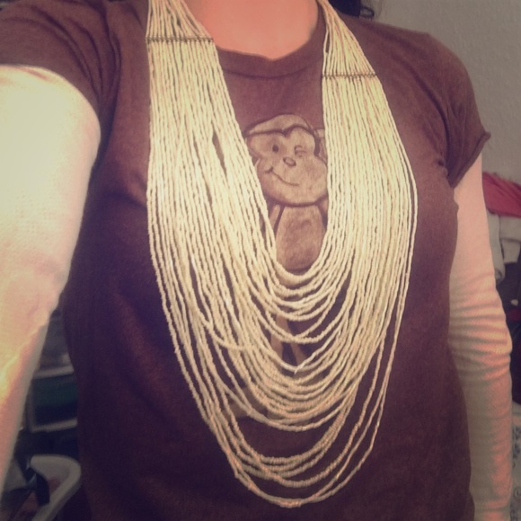 Long cream bead necklace with gold detail.