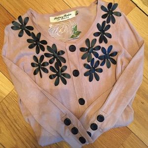 Tan cardigan with faux leather flower accent.