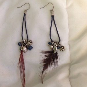 Blue dangle earrings with charms and a feather