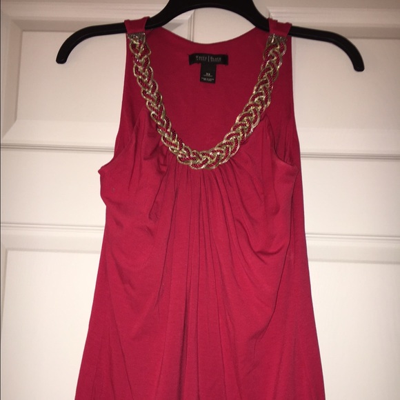 A beautiful pink coral top with jewelry detail.