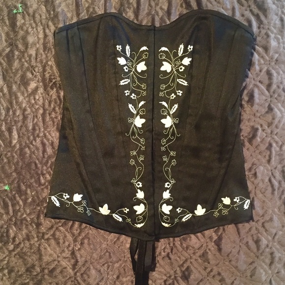 Black corset with cream flower embroidered trim.