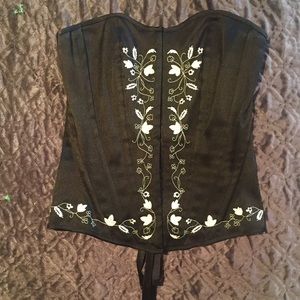 Black corset with cream flower embroidered trim.