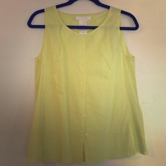 Yellow sleeveless pleated top.