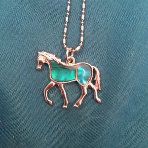 Teal shiny stone in a horse on a detailed chain