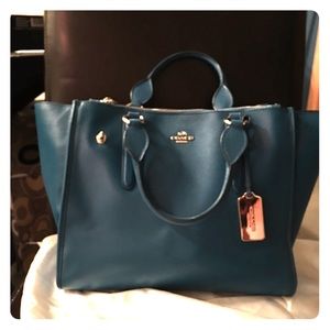 Turquoise Coach purse with gold hardware.