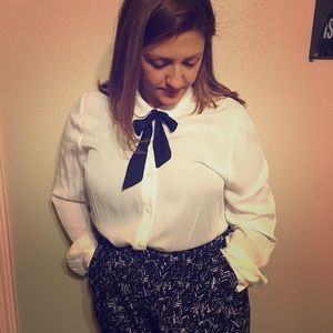 Long sleeve, button-up, creme blouse w/ black tie