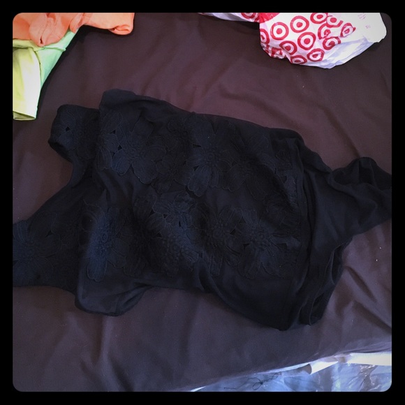 A sleeveless see through body suit .
