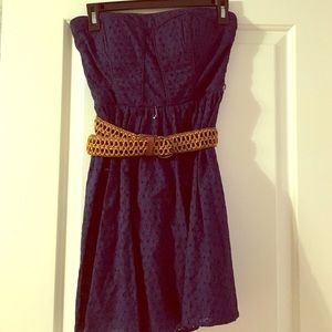 A navy blue dress with a tan belt.