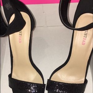 A pair of black glitter heels.